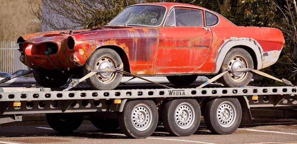 Junk car on flatbed tow-truck for removal service