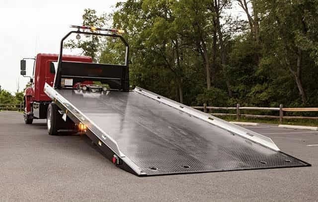 flat bed tow truck in lewisville with the ramp ready to tow
